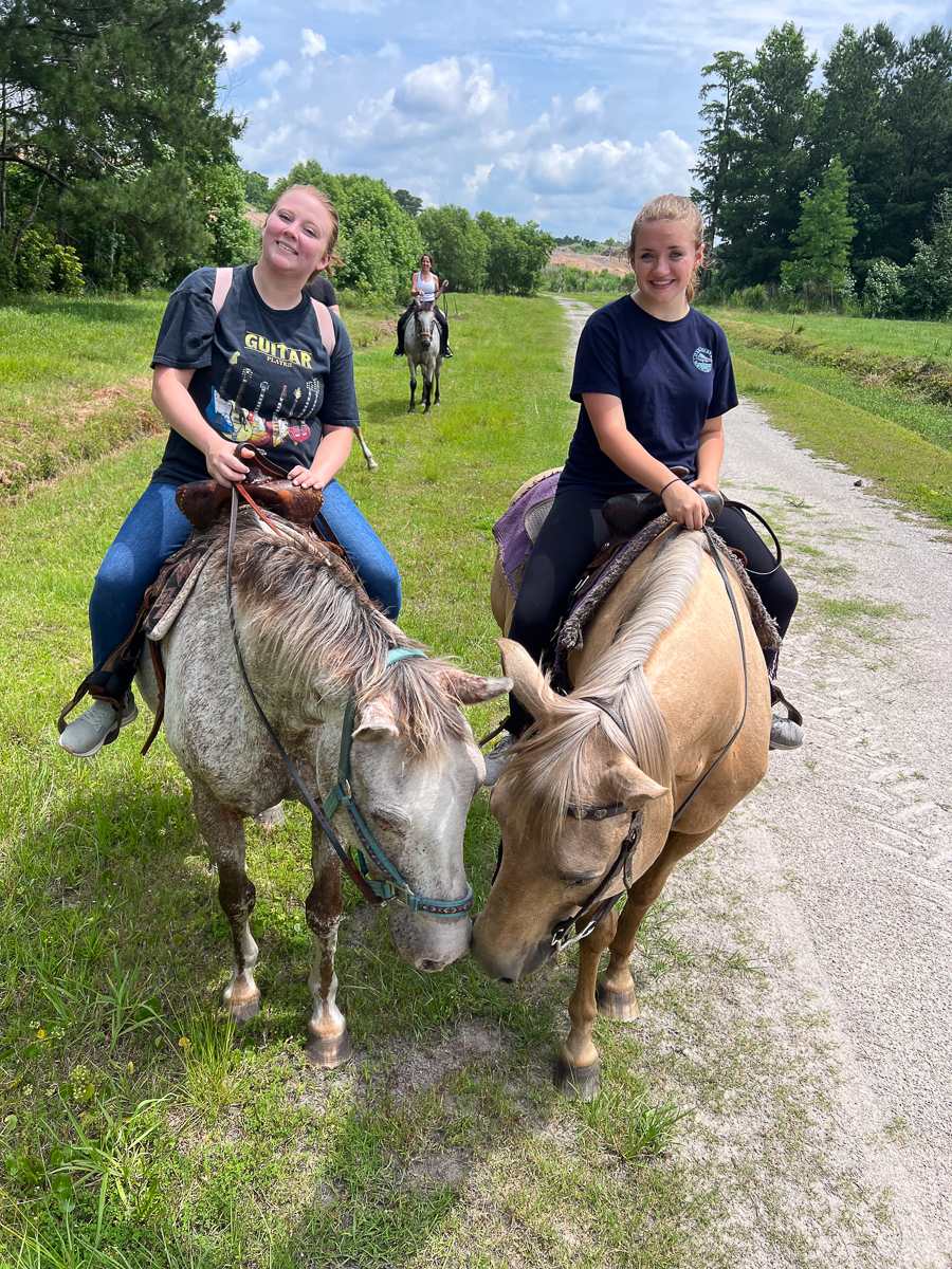 Two riders on horseback on a forest trail near Wilmington NC